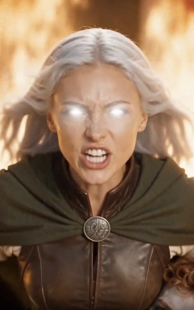 A silver-haired sorceress with glowing eyes against a wall of fire